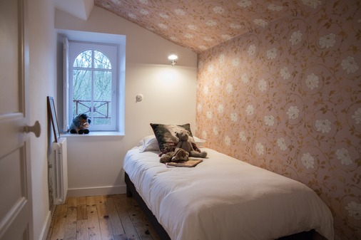 Chambre individuel avec lit simple. Une petite fenêtre près du lit laisse entrevoir la Sèvre.